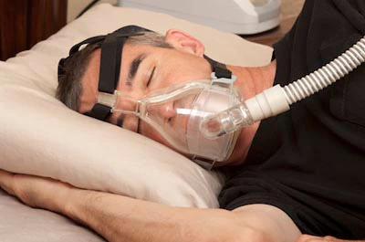man with sleep apnea sound asleep thanks to his CPAP machine