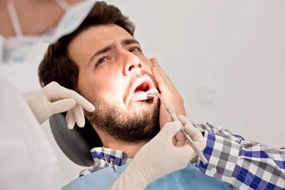 man holding his mouth from tooth pain